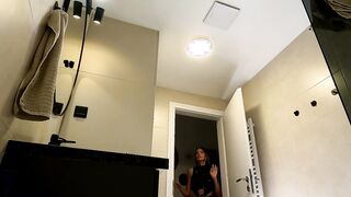 Sexy and hot horny MILF wife in see through top flashes her big boobs in a leather mini skirt in the bathroom